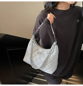 Detail of light blue quilted chain bag with silver twist lock on half-moon bag