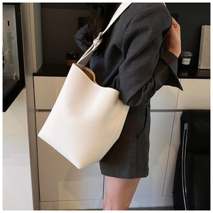 Detail der weißen Beuteltasche aus genarbtem Leder mit großem Fassungsvermögen und Schultergurt
