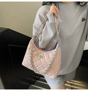 Detail of pink quilted dumpling bag with silver chain strap and metal swivel lock