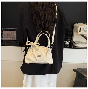Détail du sac à main en cuir grainé crème avec nœud et bandoulière amovible