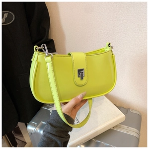 Detail of lime green faux leather shoulder bag featuring a silver metal twist lock buckle