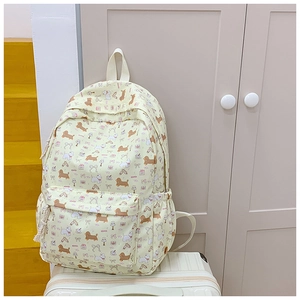 Detail of light yellow backpack with cartoon dog prints and elastic side storage pocket