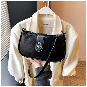 Detail view of the black textured leather shoulder bag with a silver snap button