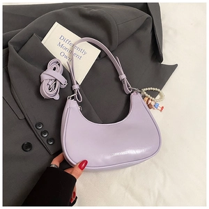Detail view of light purple underarm bag with decorative pearl chain and cute charm