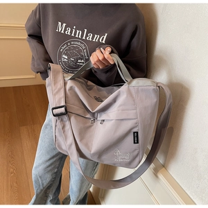 Detail of large nylon tote bag featuring a zipper pocket and cute dog graphic illustration