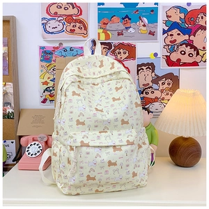 Detail view of cream canvas backpack with cute dachshund and westie dog prints on a desk
