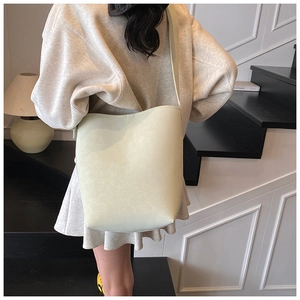Detailaufnahme einer minimalistischen salbeigrünen Leder-Eimertasche auf Innentreppen