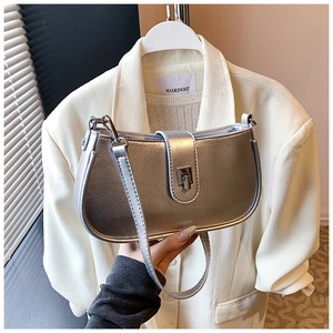 Close-up of silver metallic saddle bag with crinkled texture and sleek metal buckle