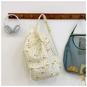 Detail view of yellow canvas backpack with cute puppy prints and spacious front pocket