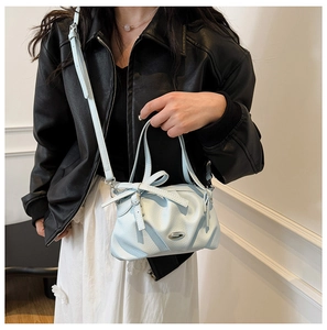 Détail du sac à main bleu clair avec nœud en cuir à texture litchi et boucle en métal argenté