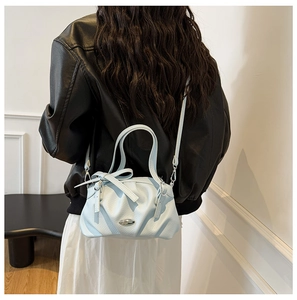 Sac à main bleu clair plissé avec boucle en métal porté en bandoulière sur le mannequin