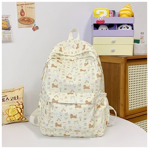 Detailed view of cream canvas backpack featuring cute puppy and ribbon prints