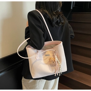 Dettaglio della borsa tote rosa con goffratura testurizzata e ciondolo a orsetto