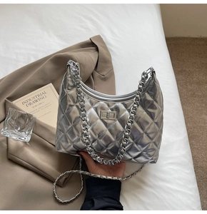 Detail of silver quilted chain bag with diamond lattice pattern and metallic turn-lock