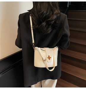White oil-wax leather bucket bag with gold cross-lock and adjustable shoulder strap