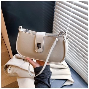 Detail of cream white leather hobo bag featuring a silver twist lock and zipper closure