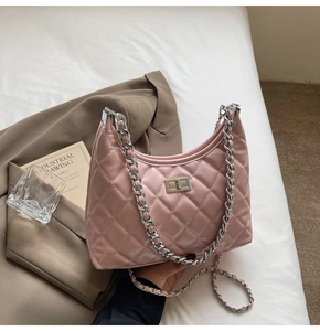 Detailed view of pink quilted patent leather dumpling bag with silver chain and lock