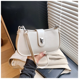 Close-up of beige faux leather bucket bag featuring a silver metal turn-lock closure