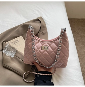 Detailed view of pink quilted handbag with silver chain straps and metallic turn-lock
