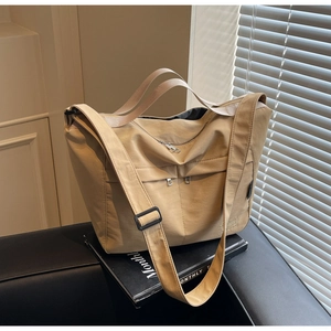 Detail view of khaki large capacity tote bag showing wide strap and zipper pockets