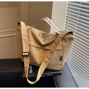 Detail of light brown tote bag with dog embroidery and adjustable shoulder strap