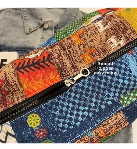 Detailed close-up of a smooth metallic zipper on a patterned ethnic canvas bag