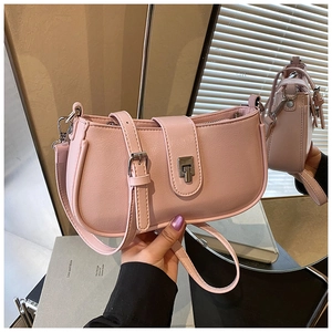 Detail of pink faux leather bag with lychee texture and silver metallic buckle closure