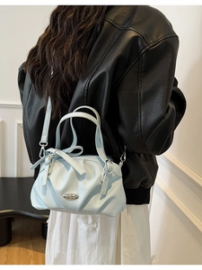 Sac à main bleu clair en cuir avec nœud papillon, design plissé et boucle argentée