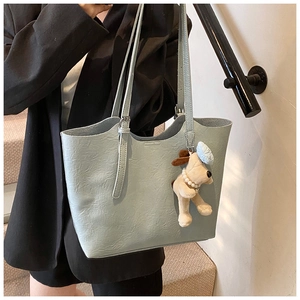 Detail of light blue tote bag with unique crinkled texture and cute puppy charm