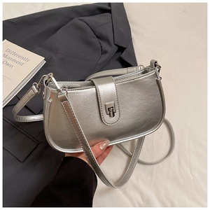 Detail of silver metallic textured hobo bag with chrome clasp and leather strap