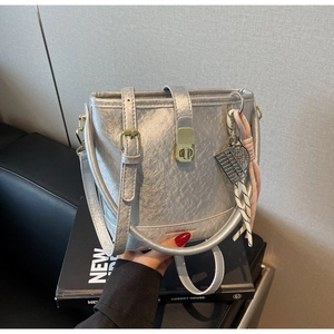 Détail du sac seau métallisé argenté avec fermoir doré et pendentif de raquette de tennis