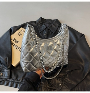 Detailed close-up of silver quilted half-moon bag with double chain strap and twist lock