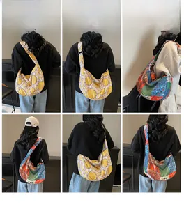 Detail view of large canvas crescent crossbody bags with floral and bohemian prints