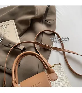 Détail du sac cabas tissé avec rabat en cuir marron et sangle à boucle métallique