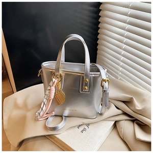 Detail of silver metallic mini tote bag with gold hardware and silk scarf decoration