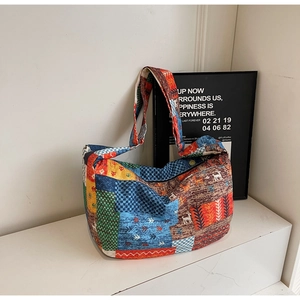 Detail of vintage patchwork canvas tote bag featuring multi-color patterns and wide strap