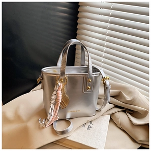 Detail of silver metallic bucket bag with FASHION & YM logo and tennis racket charm