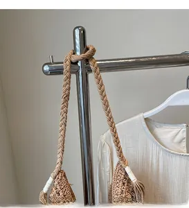 Detail of hand-woven shoulder strap and hollow crochet texture on straw beach bag