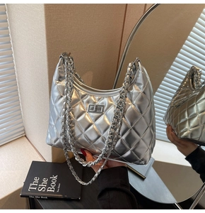 Detailed view of silver quilted chain bag with metallic finish and rotary lock