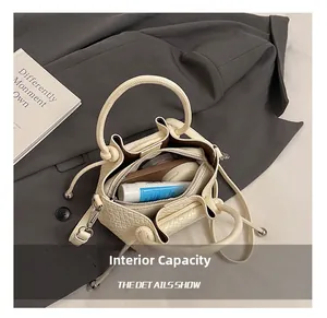 Détails montrant la capacité intérieure du sac seau plissé blanc cassé à texture tressée