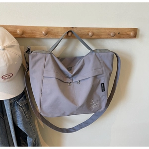 Detail of lavender nylon tote bag with front zipper pockets and adjustable strap