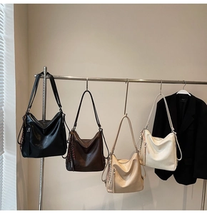 Primo piano di borse tote in pelle cerata in quattro colori con dettagli nappe intrecciate