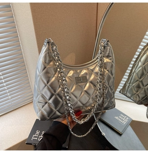 Detail of silver metallic quilted handbag with chain strap and twist-lock closure
