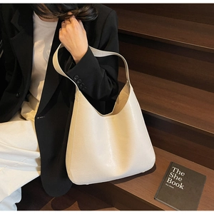 Détail d'un cabas minimaliste en cuir crème dans une scène de style urbain et chic