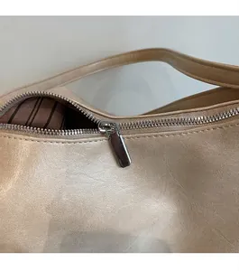 Gros plan détaillé de la fermeture éclair en métal et de la doublure rayée du sac