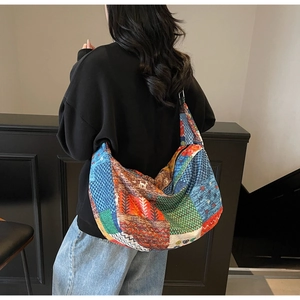 Detail of bohemian patchwork canvas tote bag featuring ethnic animal patterns and vibrant colors