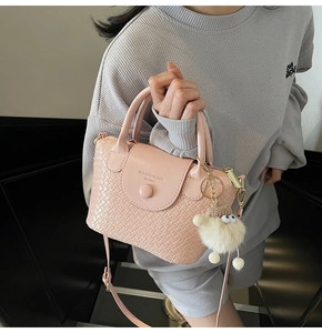 Détail du sac à main rose tissé avec fermoir magnétique et breloque en peluche mignonne