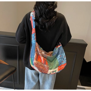 Detail of ethnic patchwork canvas crossbody bag with colorful patterns and metal buckle