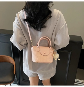 Detail der rosa Handtasche mit Webstruktur und Riemen an einem Model gezeigt