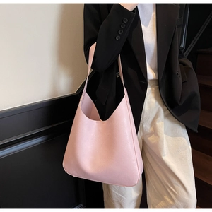 Grand sac à main rose porté à l'épaule par un mannequin en blazer noir chic